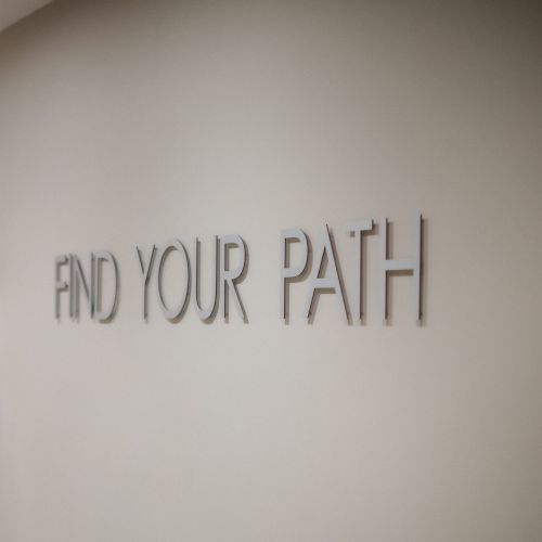 The image shows a wall with the words "FIND YOUR PATH" in large, uppercase letters.